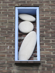 906513 Afbeelding van een kunstwerk bestaande uit platte stenen, in de zijgevel van het pand aan de oostzijde de ...
